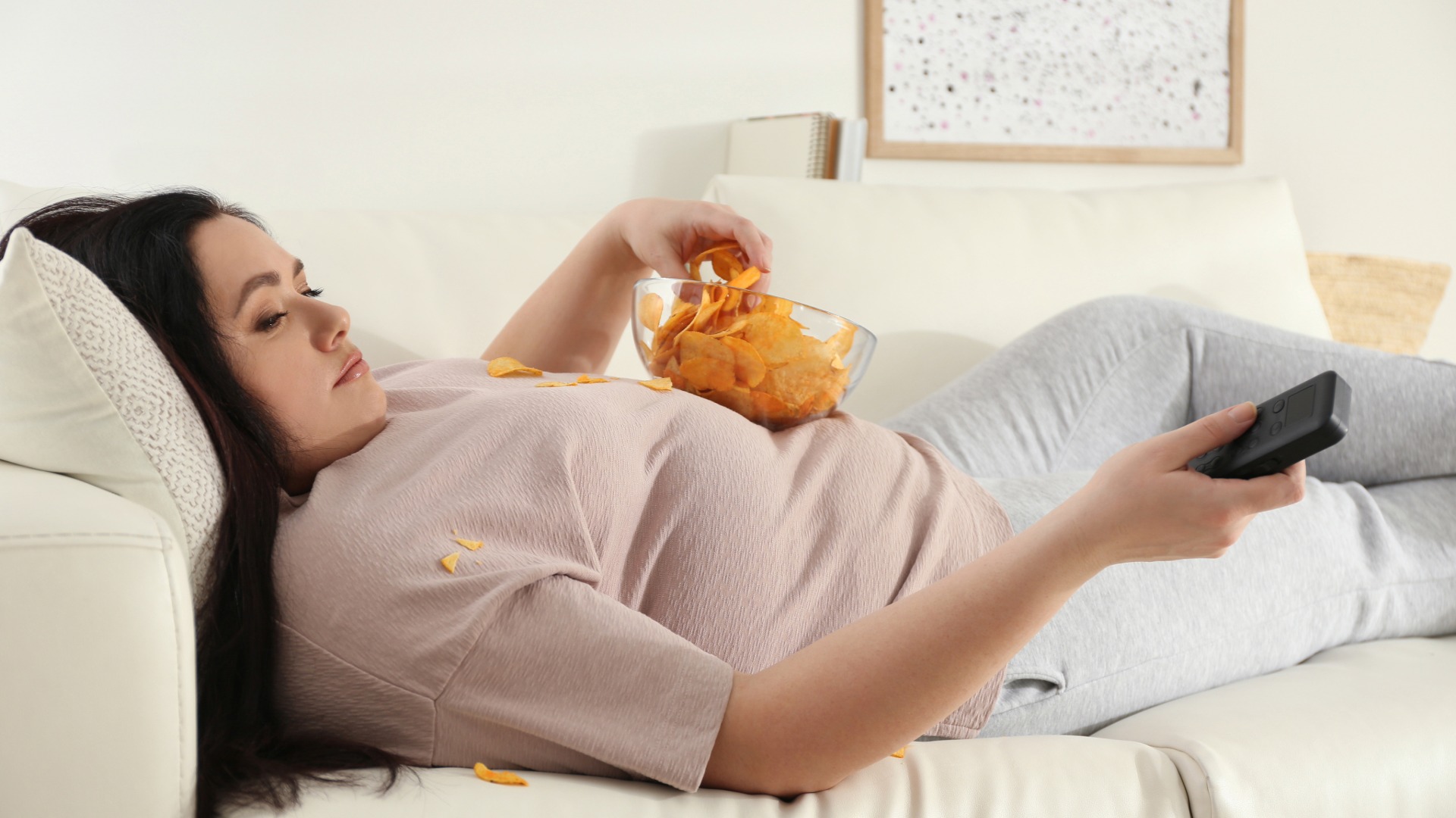 Mujer comiendo acostada en el sofá