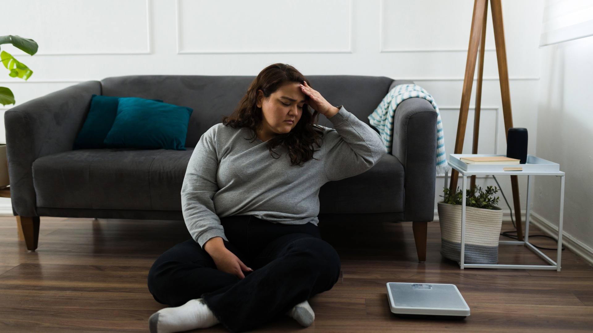 Mujer obesa mirando una báscula